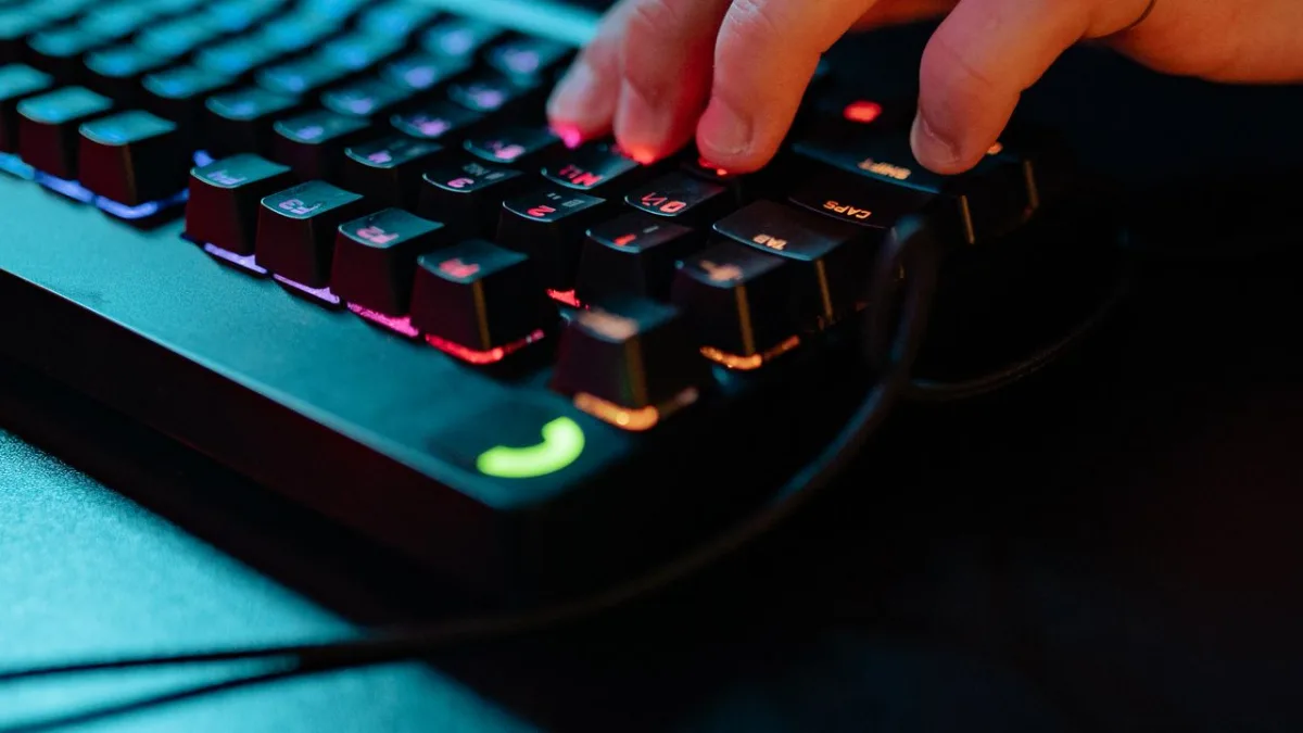 Close-up of fingers pressing the keys of an RGB mechanical keyboard